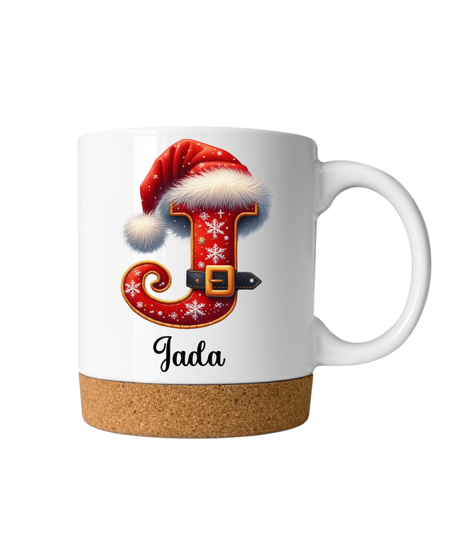 Personalisierte Weihnachts-Tasse mit Korkboden, rotem Buchstaben im Santa-Design und Namen darunter.